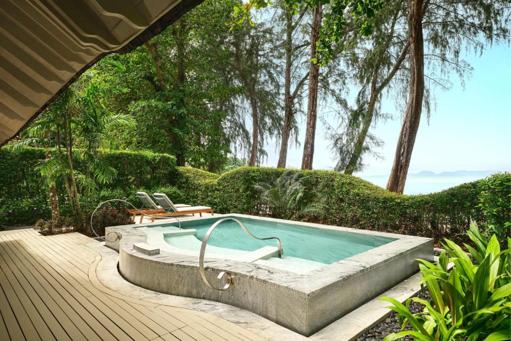a swimming pool in a yard with a wooden deck at Phulay Bay, A Ritz-Carlton Reserve in Tab Kaek Beach