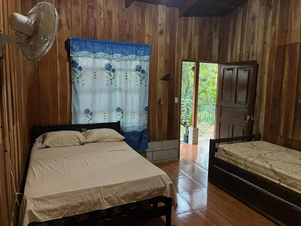 1 dormitorio con cama, ventana y puerta en Cabañas Hospedaje la Reserva, en Hojancha