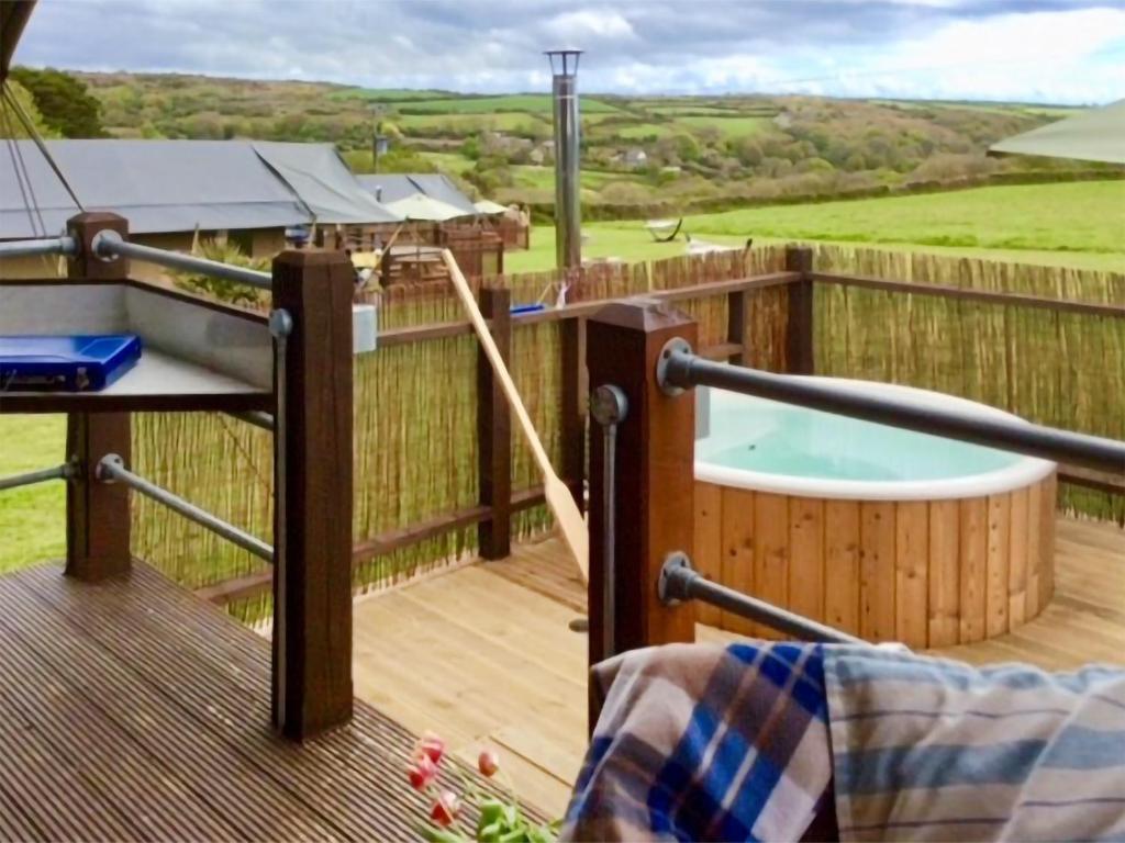 a deck with a hot tub and a jacuzzi at Buttercup - Uk45986 in Paul