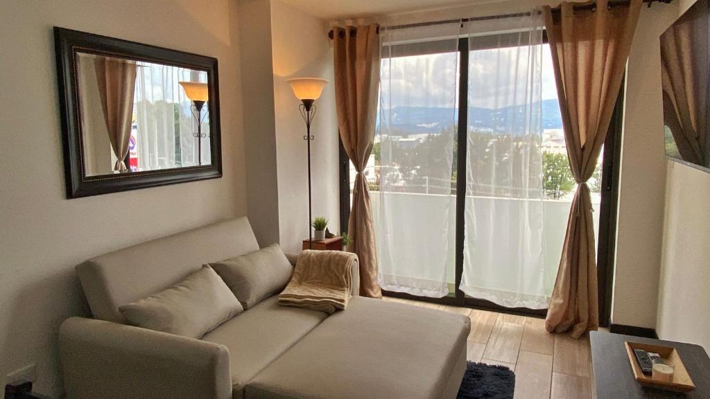a living room with a couch and a large window at Apartamento en centro Ciudad de Guatemala z12 in Guatemala