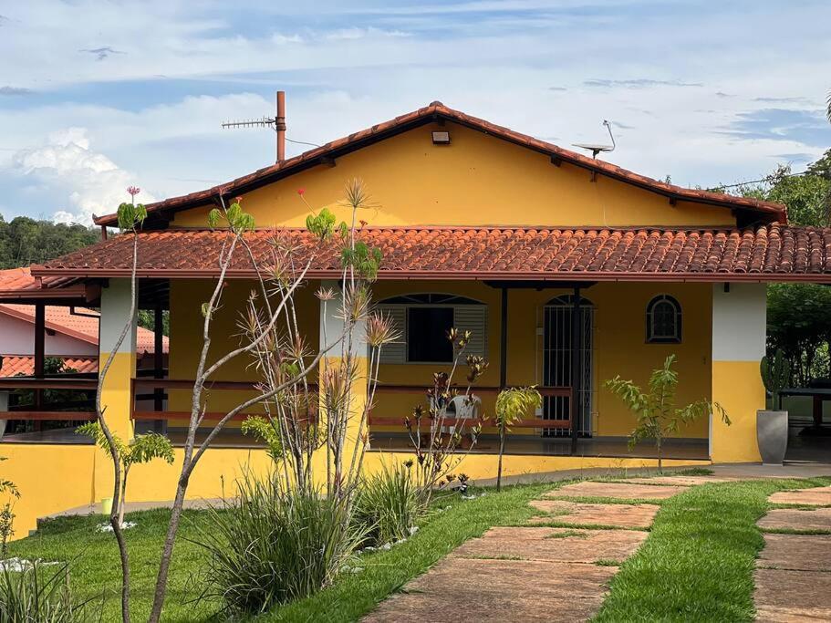 una casa amarilla con techo rojo en Sitio Igarapé, en Igarapé