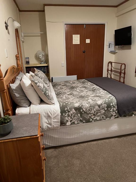 een slaapkamer met een groot bed en een houten deur bij Carly’s Place in Rotorua