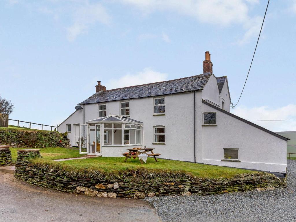a white house with a picnic table in front of it at 3 Bed in Boscastle 82896 in Boscastle