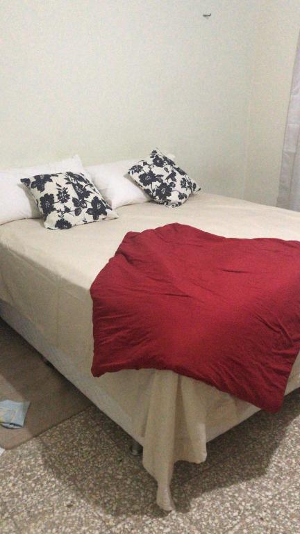 Una cama con almohadas blancas y negras. en Casa lily, en Calero