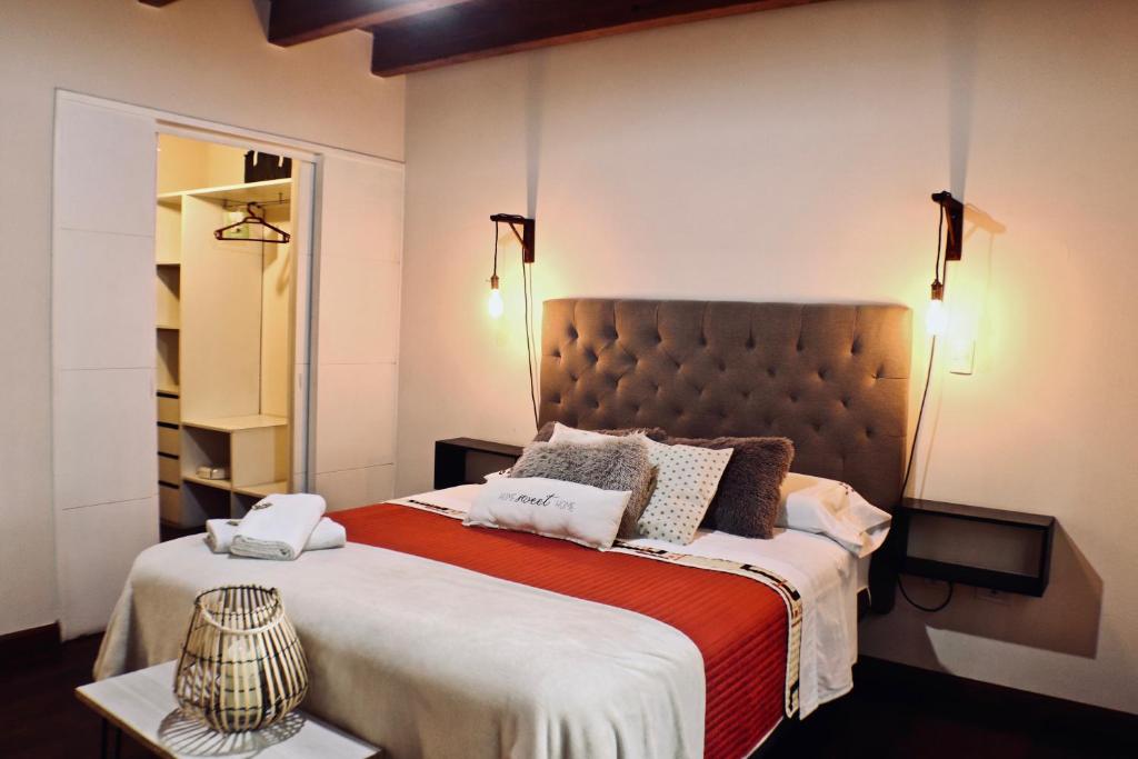 ein Schlafzimmer mit einem großen Bett mit einer orangefarbenen Decke in der Unterkunft "Tu refugio espacioso en el corazón de MENDOZA y el PARQUE" in Mendoza
