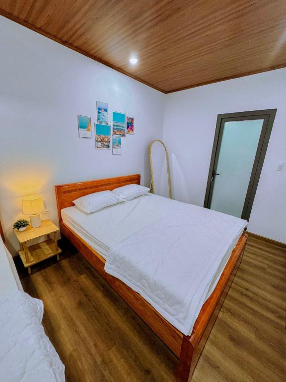 a bedroom with a large bed and a mirror at Vile Villa- Homestay 2 Đảo Phú Quý in Cu Lao Thu