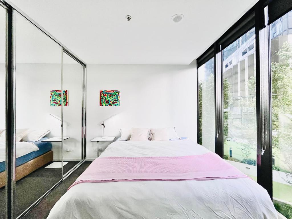 a bedroom with a bed and a large window at Lakeside Apartment with Great Views in Belconnen