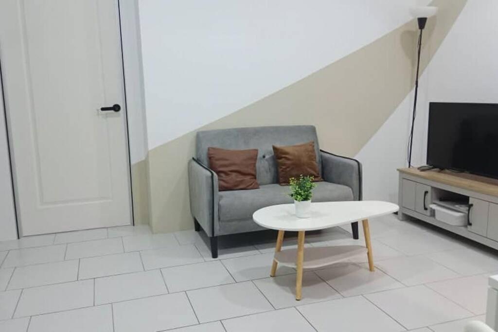 a living room with a couch and a table at 3 Bedrooms -Astetica-The Mines in Seri Kembangan