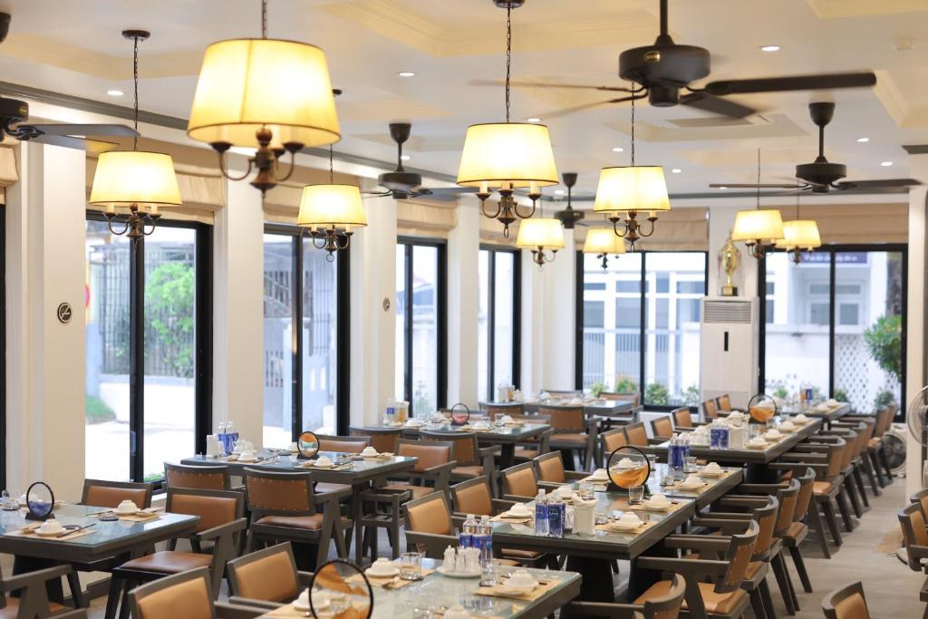 SALA HOTEL HUE في هوى: غرفة طعام مع طاولات وكراسي ونوافذ