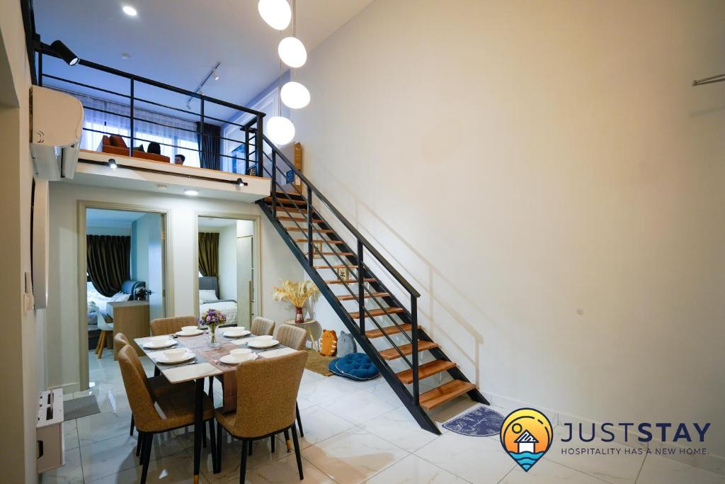 a dining room with a table and a spiral staircase at Arte Cheras by Just Stay in Kuala Lumpur