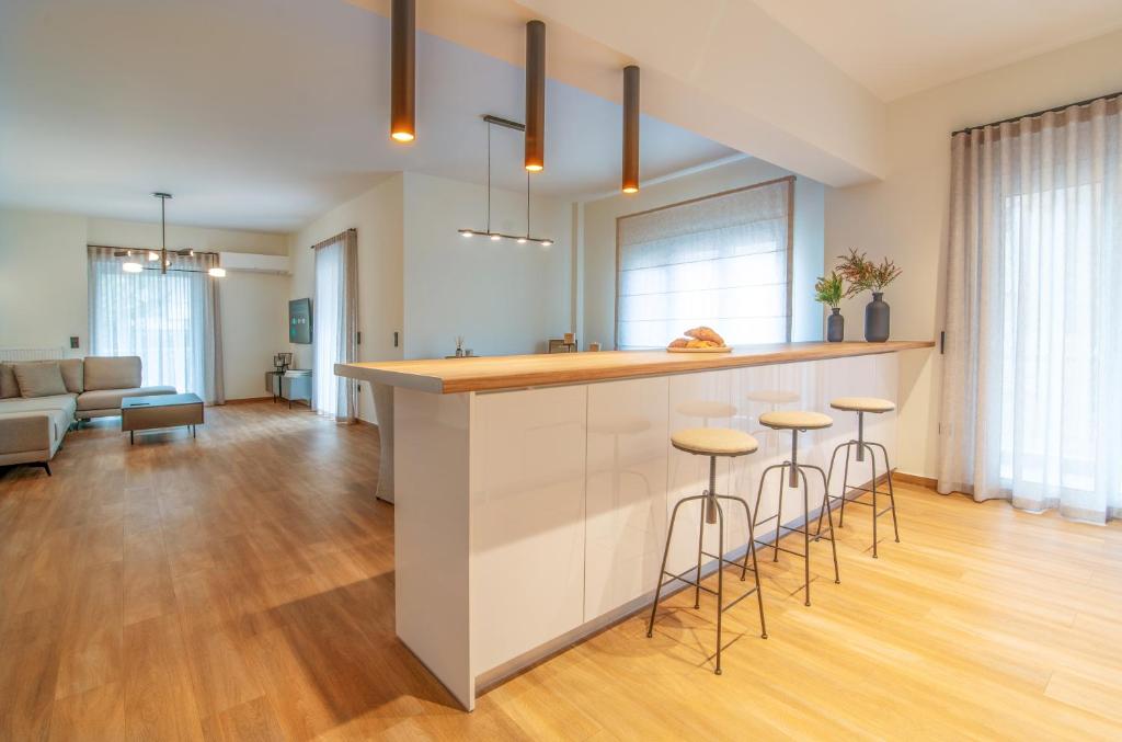 a kitchen and living room with a counter and stools at Central Marousi 3BR Gem in Athens
