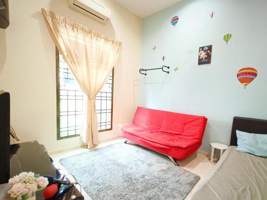 a red couch in a room with a window at Melaka Homestay with pool 4BR Semi-D,BBQ,KTV,Billiard 15pax DeStarryVilla in Malacca