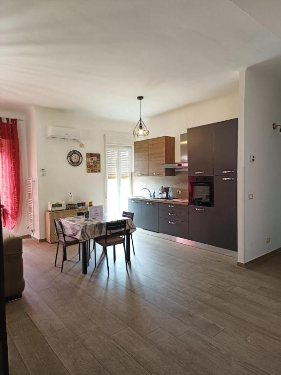ein Wohnzimmer mit einem Tisch und einer Küche in der Unterkunft CASA MIA in Taranto