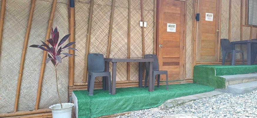una stanza con due sedie e un tavolo di fronte a un edificio di Ecostay Panglao Resort Hotel a Panglao