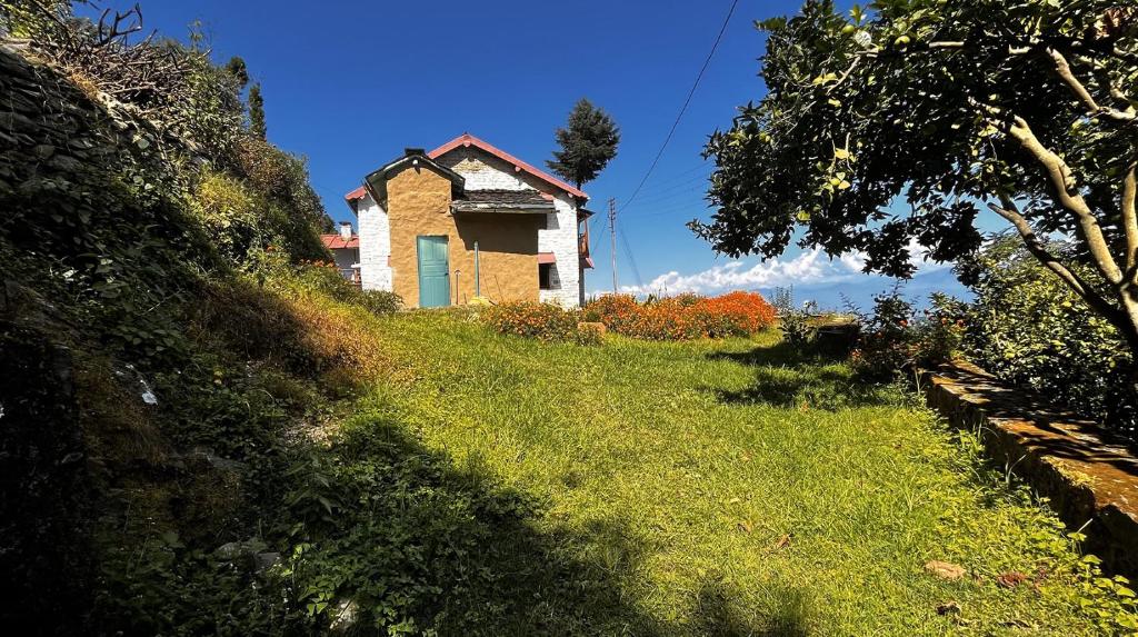 une vieille maison sur le flanc d'une colline dans l'établissement Adara Farmstay, à Pauri