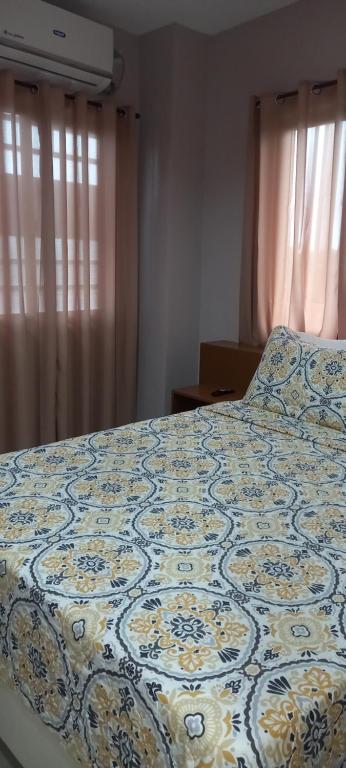 Una cama con un edredón azul y blanco. en Lorraine Suites en Borongan