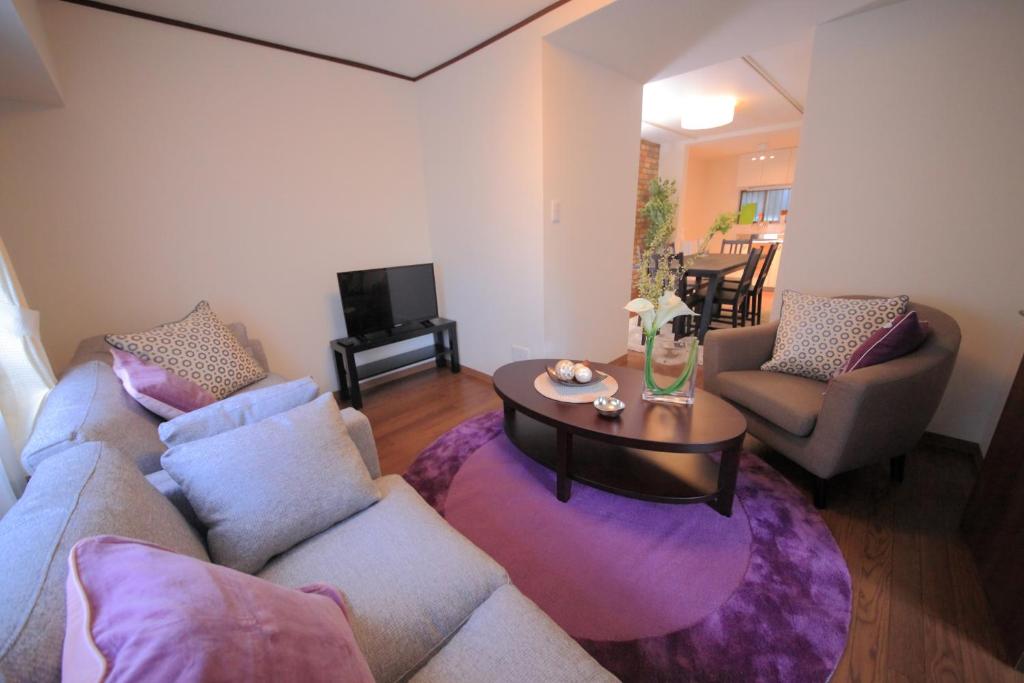 een woonkamer met een bank en een tafel bij Villa Shin-Imamiya in Osaka
