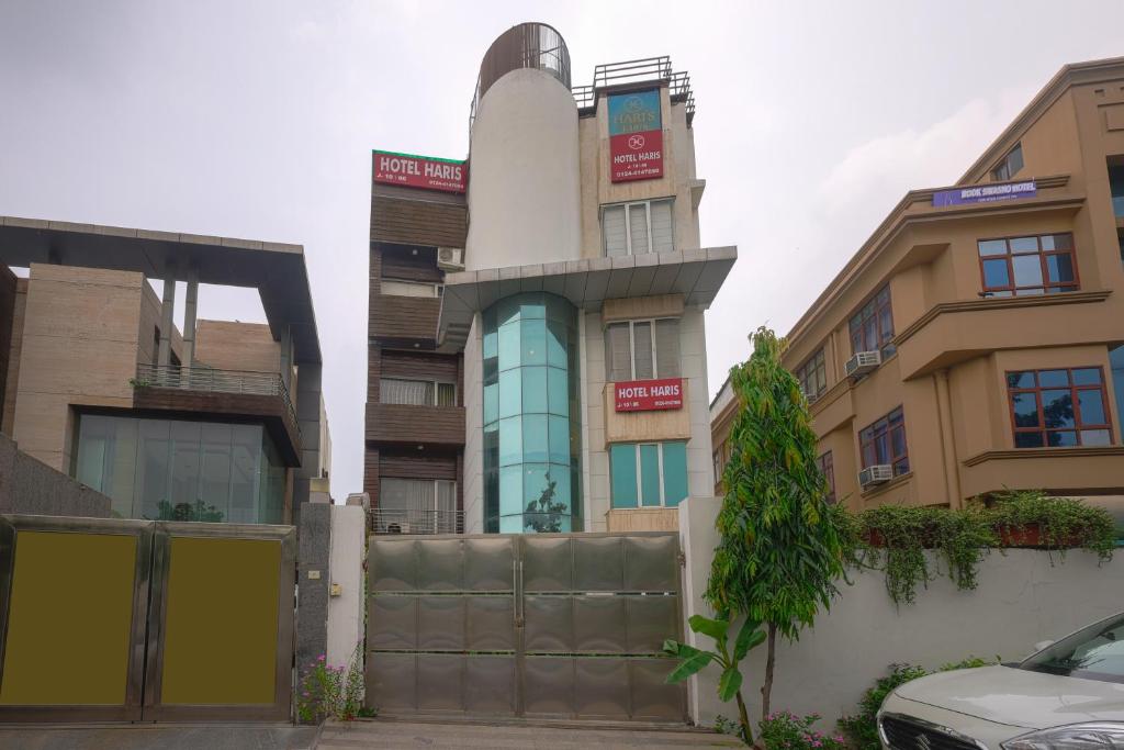 ein Gebäude in der Mitte einiger Gebäude in der Unterkunft Hotel Haris MG Road Gurugram in Gurgaon
