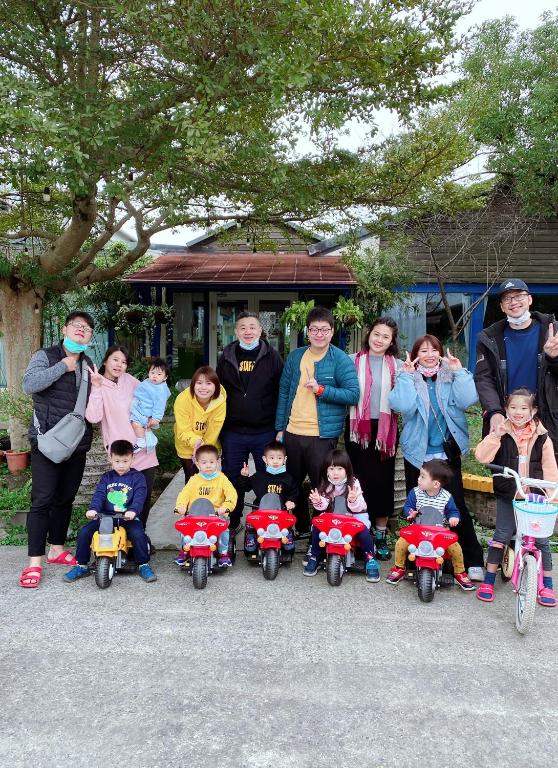 a group of people posing for a picture with toy motorcycles at Follow Me designed B&amp;B in Dongshan