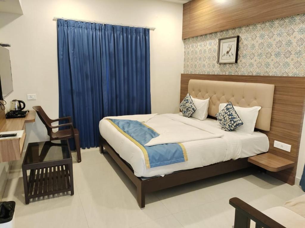 a bedroom with a bed and a blue curtain at SMA Grand inn, Triplicane in Chennai