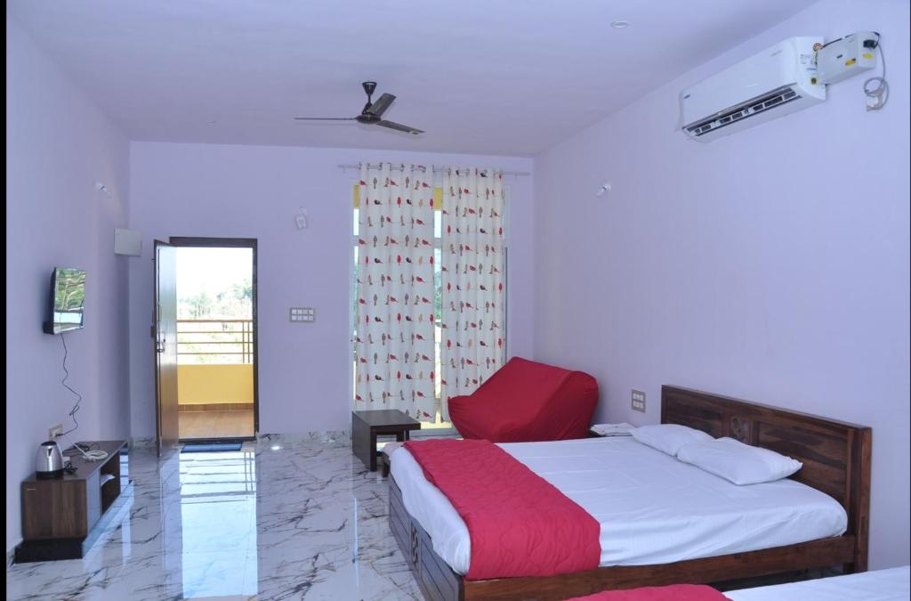 een slaapkamer met een bed en een rode stoel bij Encanto Farmstay in Mysore