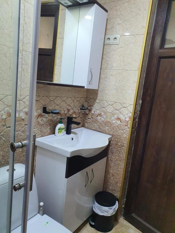 a bathroom with a sink and a toilet and a mirror at Prima home 