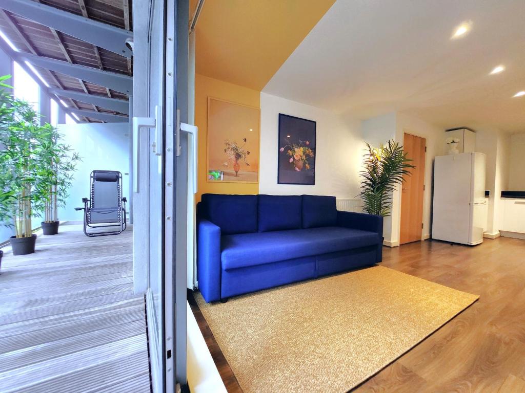 un soggiorno con divano blu in una casa di RIVERSIDE OASIS station-parking-riverboat a Woolwich