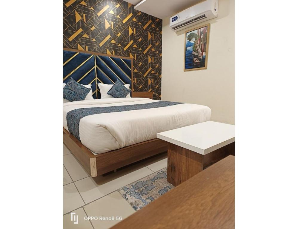 um quarto com uma cama king-size e uma cabeceira em madeira em Hotel RR, Vadodara em Vadodara