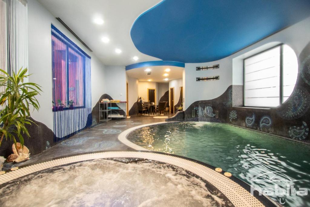 a large swimming pool in a house with a tub at Cozy house with sauna, pool and private garden in Riga