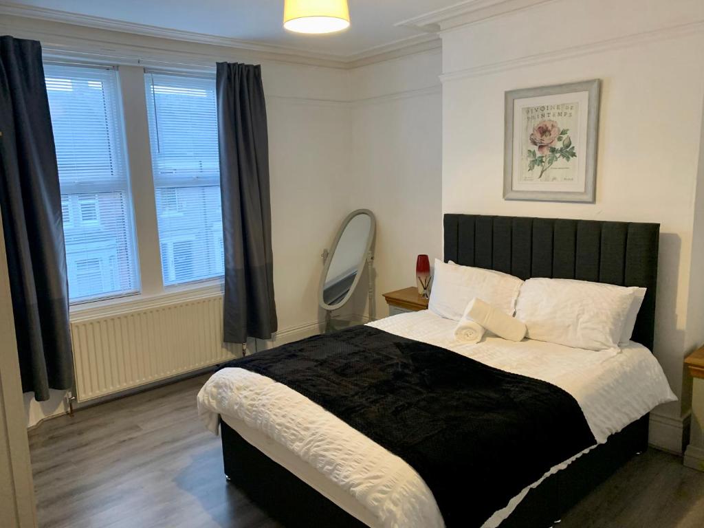um quarto com uma cama grande e uma janela em Blossom Holiday Lets - 3 Bed Bensham Apartment em Gateshead