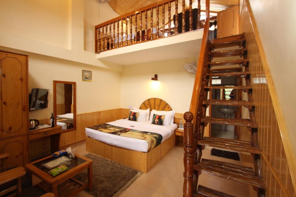 a bedroom with a bed and a spiral staircase at Purnima Guest House, Old Kasol in Kasol