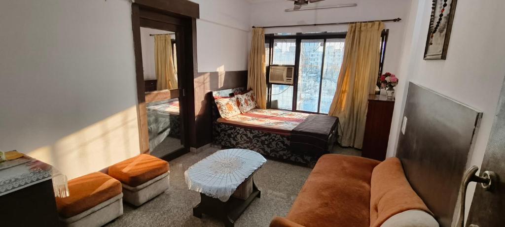 salon z kanapą i oknem w obiekcie Dreamland- The flat of your dreams/ Entire 1bhk Apartment w Bombaju