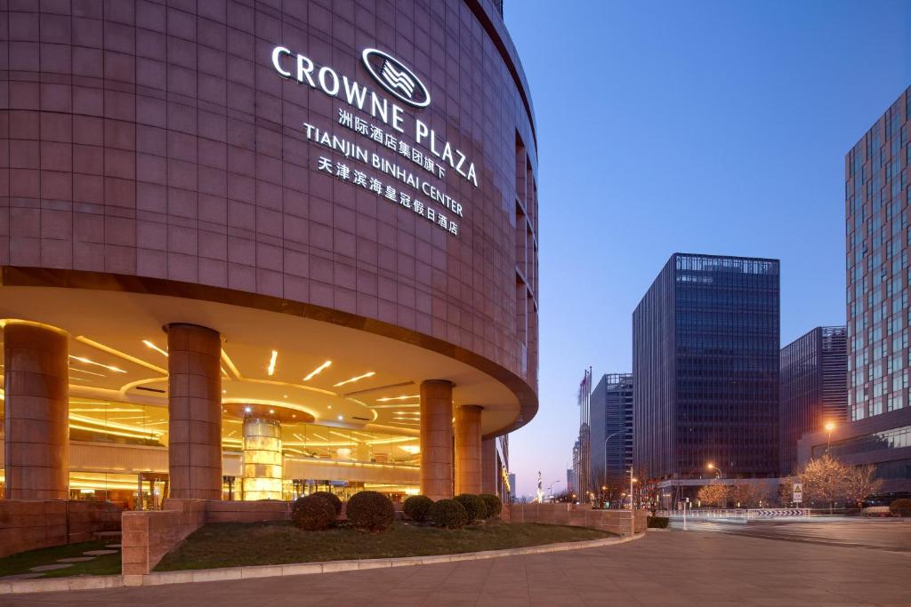 un bâtiment avec un panneau sur son côté dans l'établissement Crowne Plaza Tianjin Binhai Center, an IHG Hotel, à Binhai