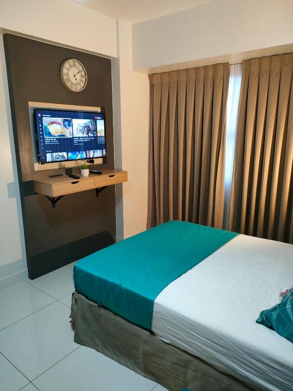 セブシティにあるHorizon 101 Cebu by D' King's Placeのベッドとテレビがあるホテルの部屋
