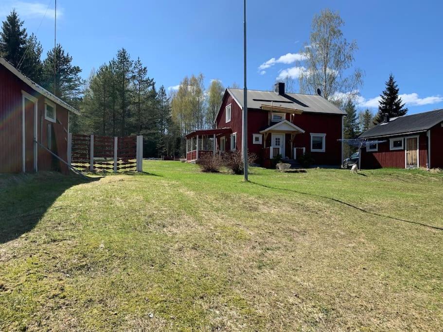 a red barn and a house in a field at 30 min from Northvolt/5 min from Boliden in Boliden