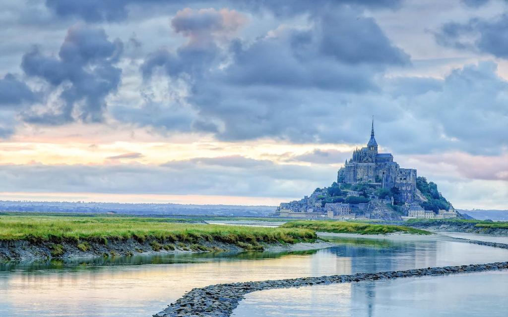 a castle on an island in a river at Gîte le Chausey Mont Saint Michel in Pontorson