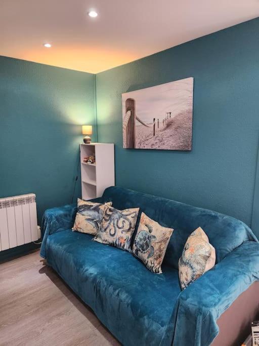 un salon avec un canapé bleu avec des oreillers dans l'établissement Biscarrosse - Plage à 300m Superbe appart. 4 Pers, à Biscarrosse