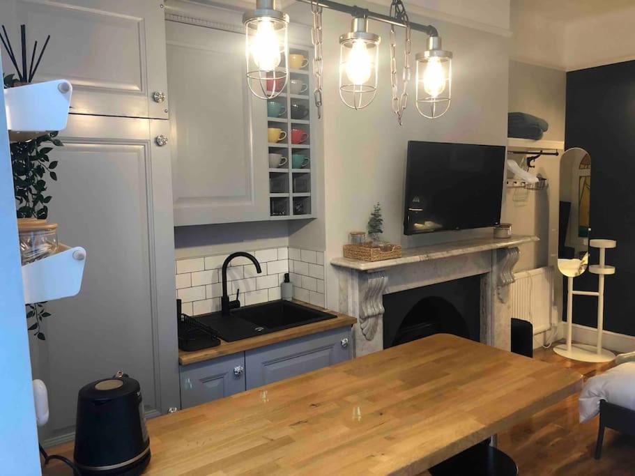 a kitchen with a table and a sink and a fireplace at Studio 77 - Central. Free on street parking. in Sheffield