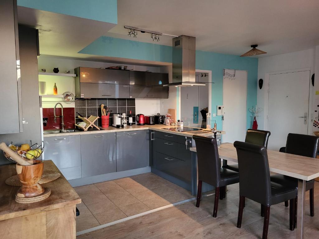 a large kitchen with a wooden table and chairs at Appartement vue Seine - Duplex 3 terrasses - 3 Chambres in Saint-Ouen