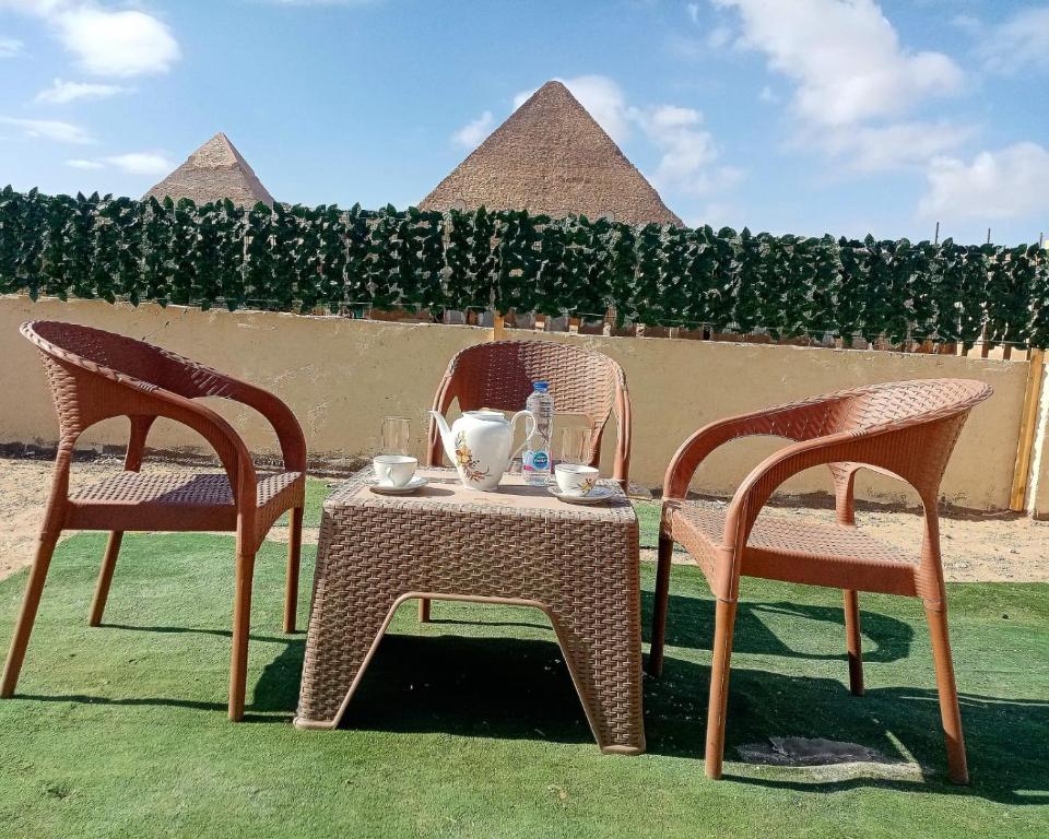 two chairs and a table with a tea set on it at ElBayt motel in Cairo