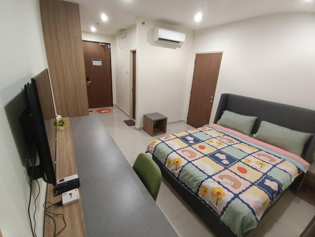 Zimmer mit einem Bett und einem Schreibtisch mit einem TV in der Unterkunft Kozi Square with Infinity Pool II in Kuching