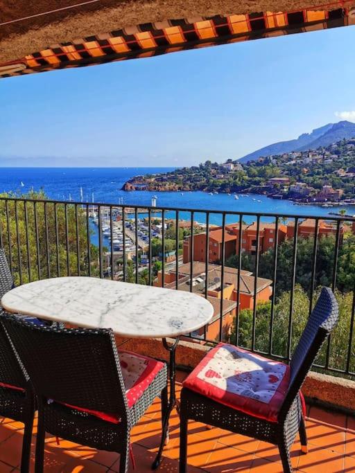 une table et des chaises sur un balcon avec vue sur l'océan dans l'établissement Petit Mas Coquet dans l'Esterel, à Théoule-sur-Mer
