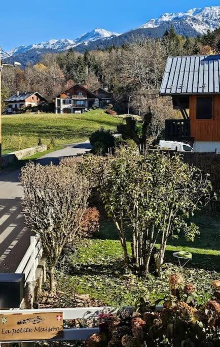 a view of a garden with trees and a house at La Petite Maison in Bonvillard
