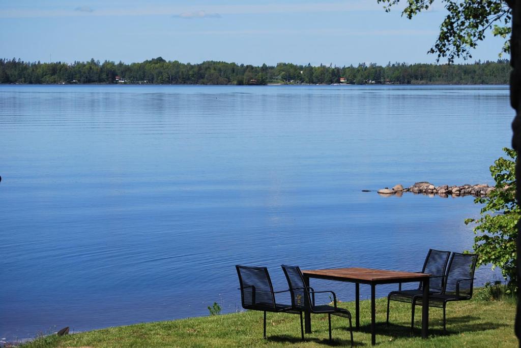 einen Tisch und Stühle neben einem See in der Unterkunft Gullranda in Älmhult