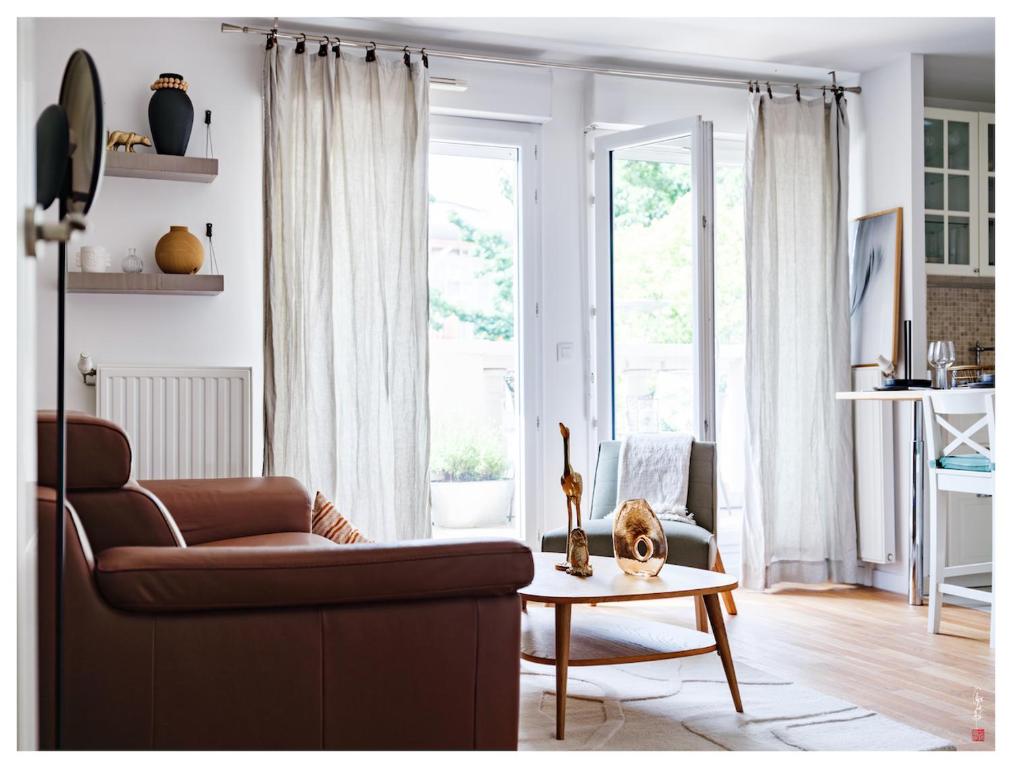 sala de estar con sofá y mesa en Magnifique F3 Classé 3 Étoiles à 20 min de Paris & Disney, en Villiers-sur-Marne