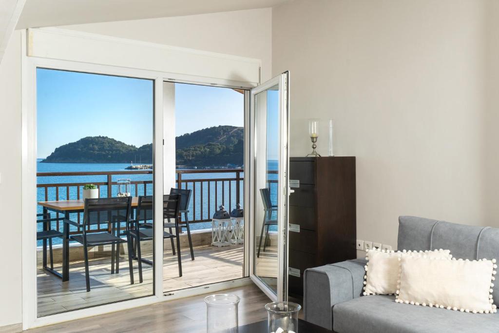 a living room with a view of the ocean at Dimar Apartments in Olympiada