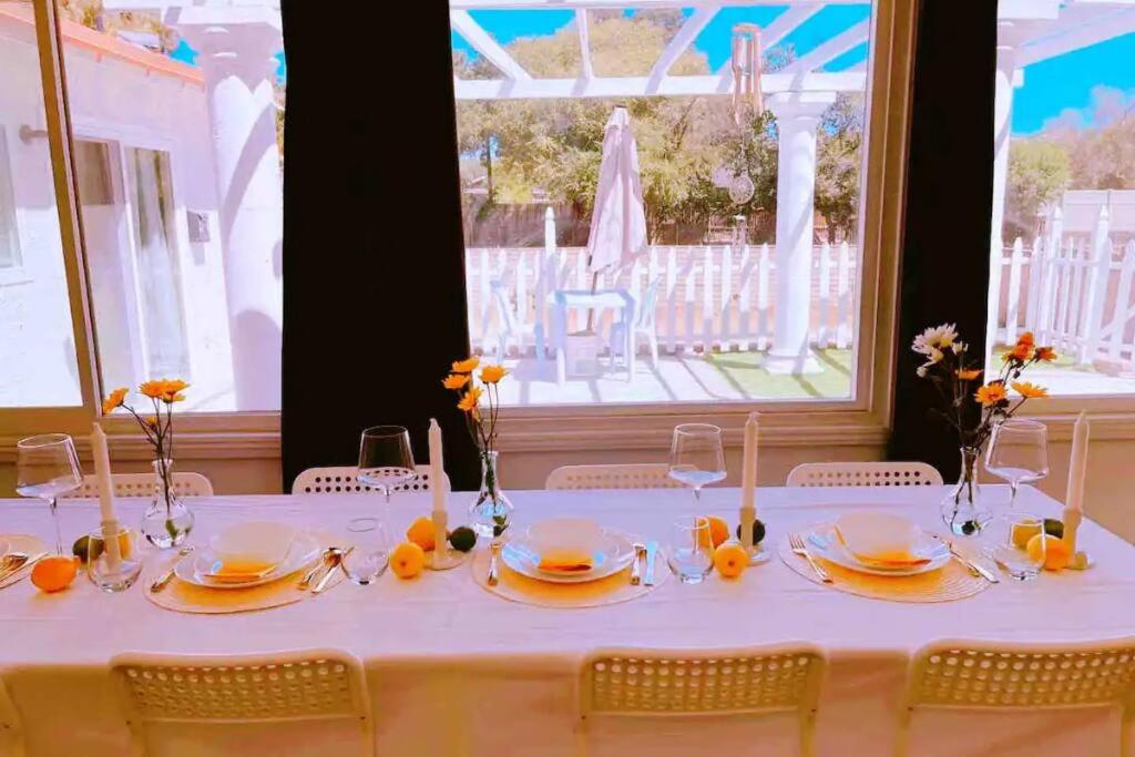 een witte tafel met gele bloemen in vazen erop bij Cozy 4BR Designer House in West Covina