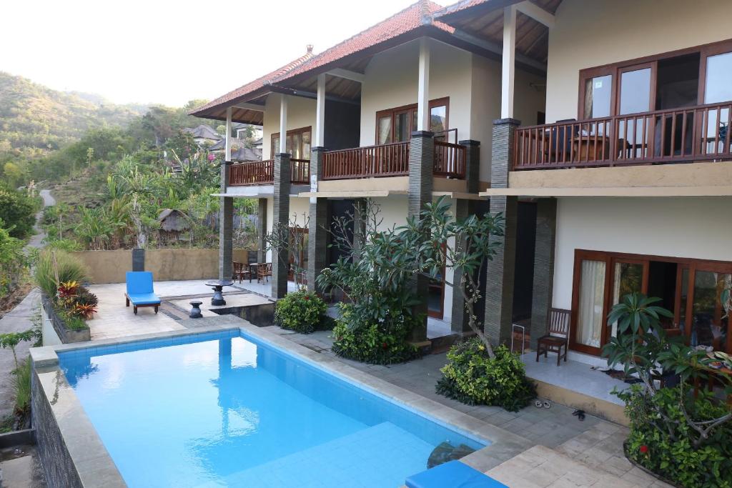 a house with a swimming pool in front of it at Anugerah Villas in Amed