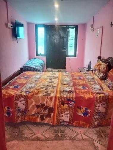 a bedroom with a bed with a colorful blanket on it at J Rooms&Dormentary in Madurai