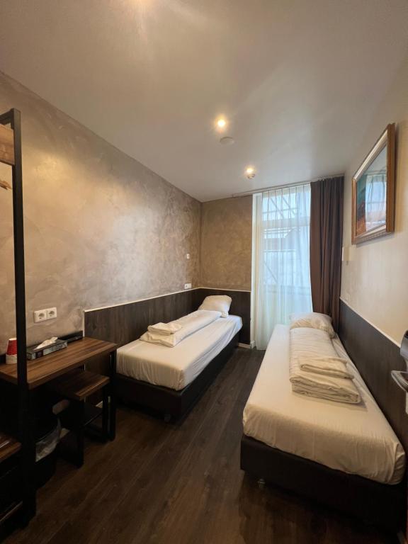 Pokój hotelowy z 2 łóżkami i lustrem w obiekcie Dam Hotel w Amsterdamie